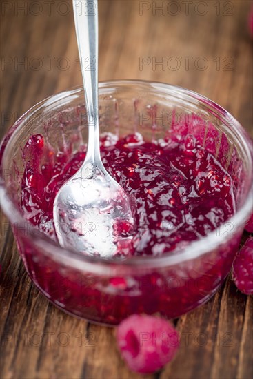 Fresh made Raspberry Jam on an old and rustic wooden table, selective focus, close-up shot