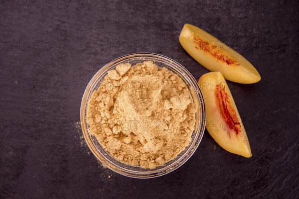 Peach powder on a vintage slate slab as detailed close-up shot, selective focus