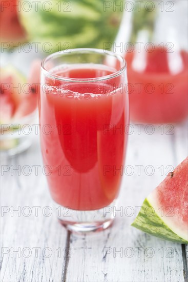 Homemade Watermelon Smoothie on an wooden table (selective focus) as detailed close-up shot