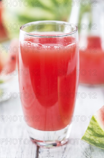 Homemade Watermelon Smoothie on an wooden table (selective focus) as detailed close-up shot