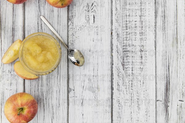 Homemade Applesauce (selective focus, close-up shot) on vintage background with some fresh fruits
