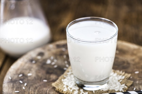 Wooden table with Rice Milk (detailed close-up shot, selective focus)