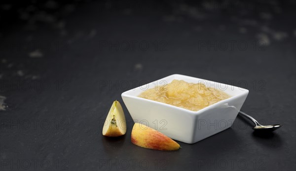 Homemade Applesauce (selective focus, close-up shot) on vintage background with some fresh fruits