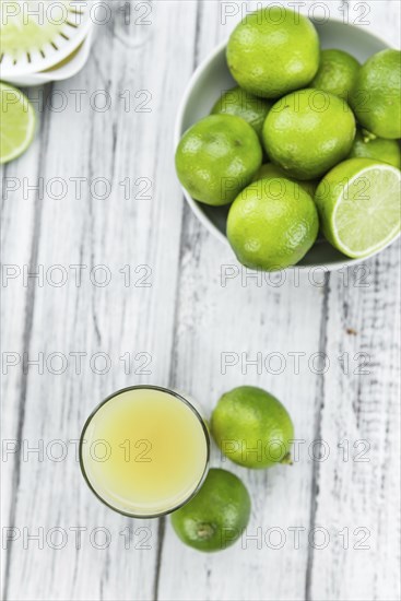 Fresh made Fresh Lime Juice on an old and rustic wooden table (selective focus, close-up shot)