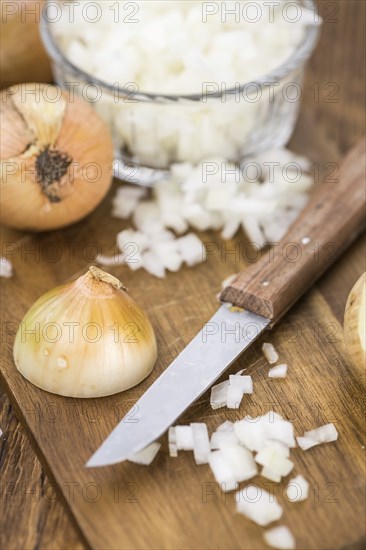 Chopped white onions on an old wooden table as detailed close-up shot, selective focus