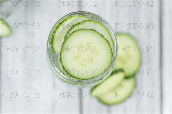 Cucumber Water on rustic wooden background as close-up shot