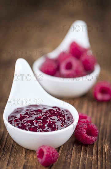 Fresh made Raspberry Jam on an old and rustic wooden table, selective focus, close-up shot