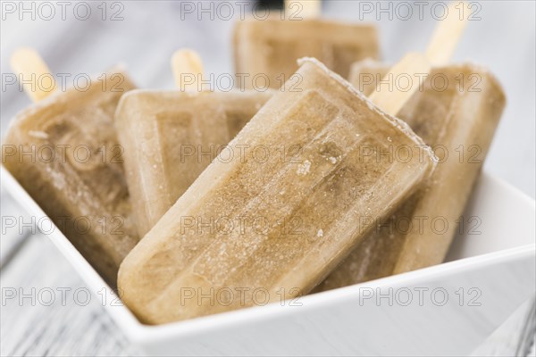 Some homemade Cola Popsicles (close-up shot, selective focus) on vintage background