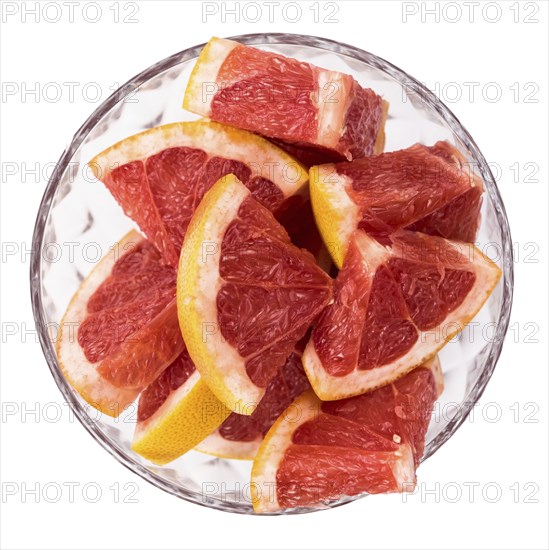 Portion of chopped Grapefruits isolated on white background (close-up shot)