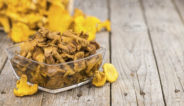 Preserved chanterelles on an old wooden table as detailed close-up shot, selective focus