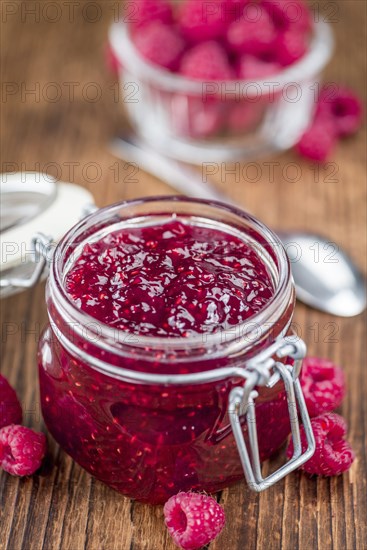 Homemade Raspberry Jam on an wooden table as detailed close-up shot, selective focus