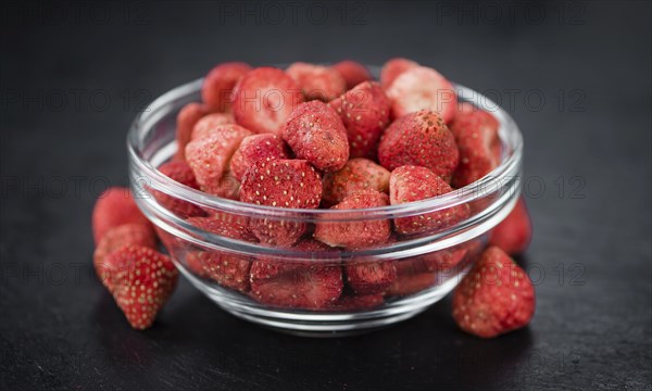 Some fresh Dried Strawberries on a vintage slate slab, selective focus, close-up shot