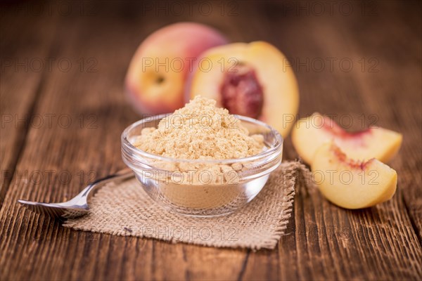 Ground Peaches as high detailed close-up shot on a vintage wooden table, selective focus
