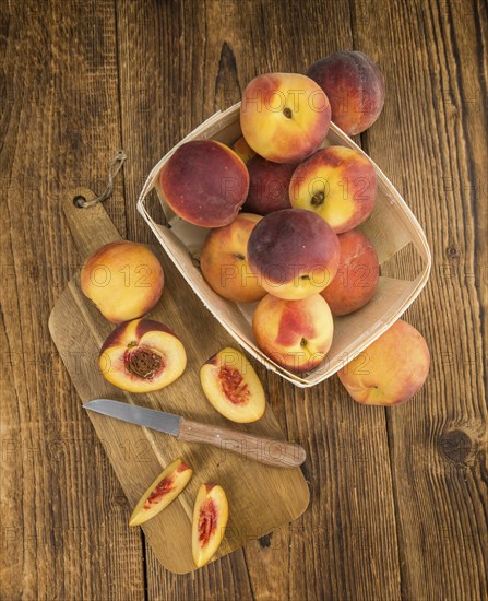 Peaches on an old wooden table as detailed close-up shot, selective focus