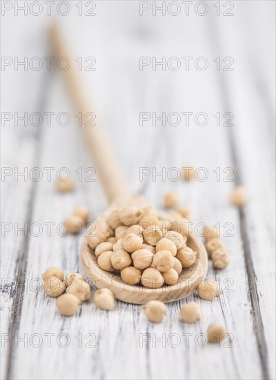 Dried Chickpeas as high detailed close-up shot on a vintage wooden table, selective focus