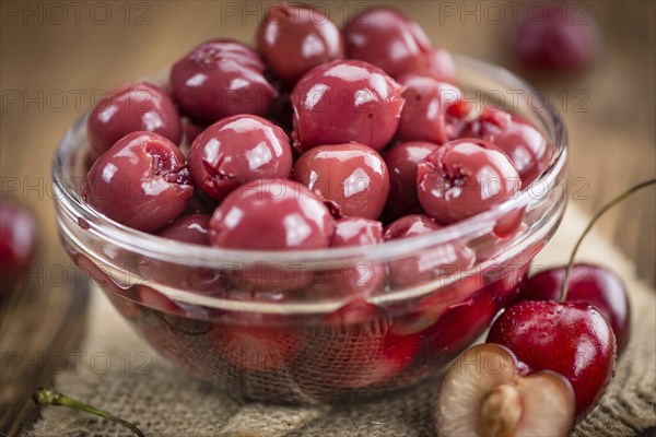 Preserved Cherries on an old wooden table as detailed close-up shot, selective focus