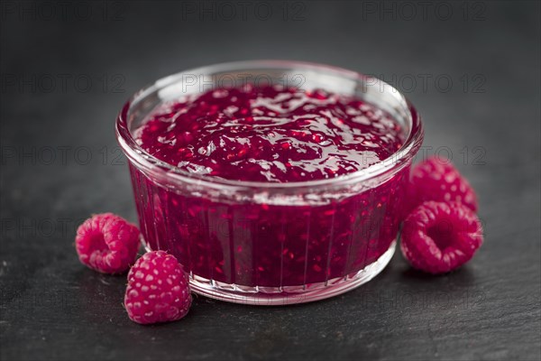 Some Raspberry Jam on a slate slab as detailed close-up shot, selective focus