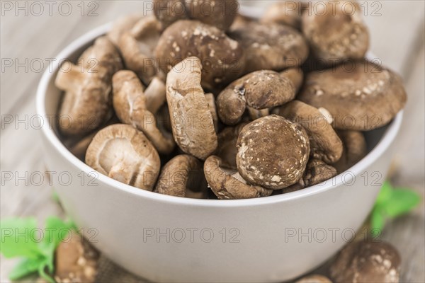 Shiitake mushrooms on an old wooden table as detailed close-up shot, selective focus