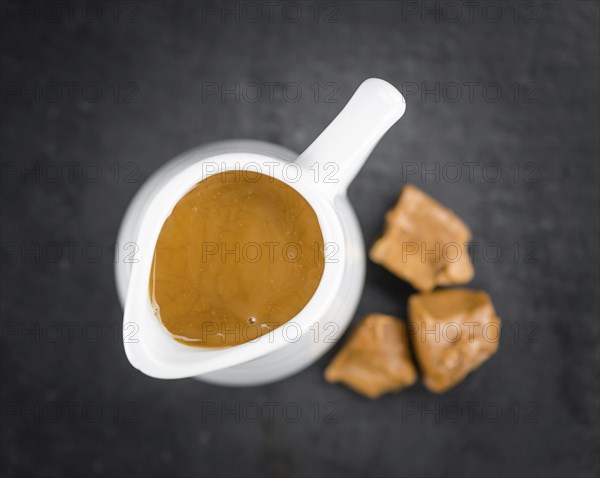Caramel Sauce on a vintage slate slab (close-up shot, selective focus)