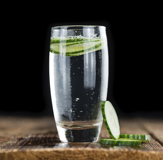 Fresh made Cucumber Water as high detailed close-up shot on a vintage wooden table, selective focus