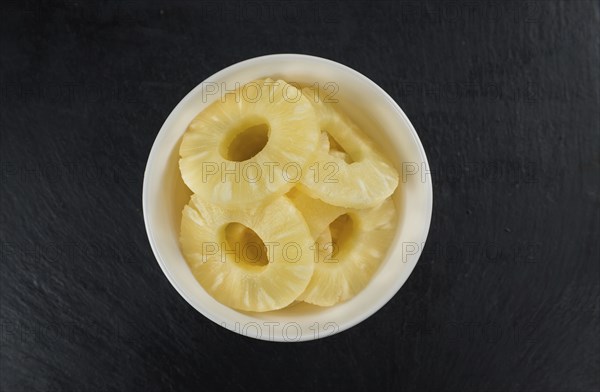 Some fresh Preserved Pineapple Rings on a vintage slate slab, selective focus, close-up shot