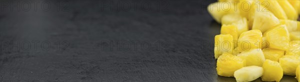 Portion of Pineapple (sliced) on a rustic slate slab, selective focus, close-up shot