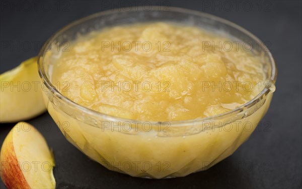 Homemade Applesauce (selective focus, close-up shot) on vintage background with some fresh fruits