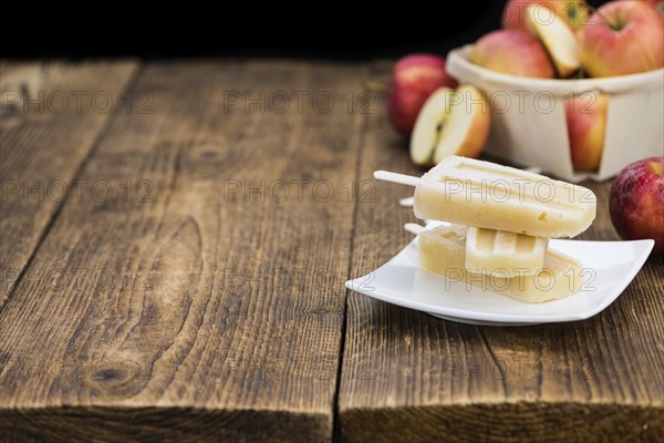 Portion of homemade Apple Popsicles (selective focus, close-up shot) on a vintage background
