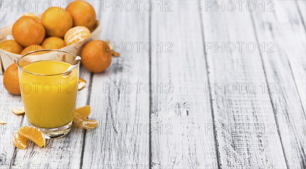Portion of fresh made Tangerine Juice (close-up shot, selective focus)
