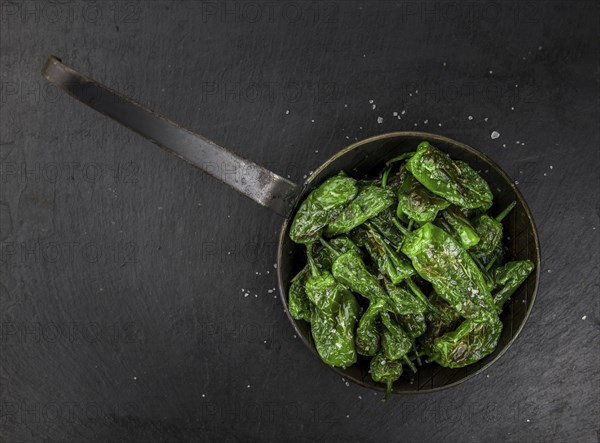 Portion of Pimientos de Padron on a rustic slate slab, selective focus, close-up shot
