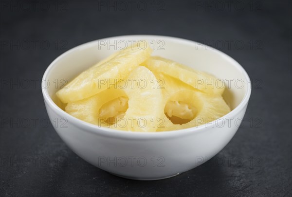 Preserved Pineapple Rings on a vintage slate slab as detailed close-up shot, selective focus