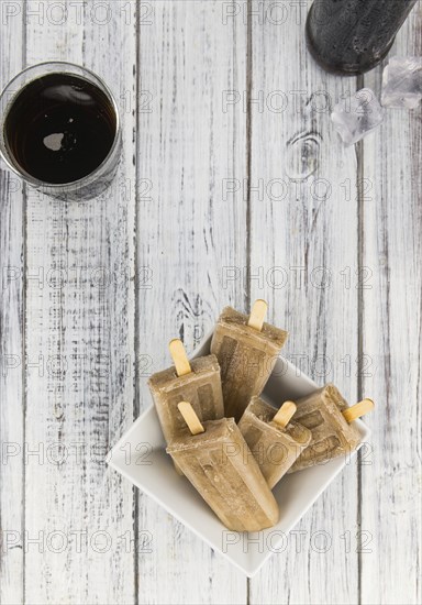 Cola Popsicles (selective focus) on a vintage background as detailed close-up shot