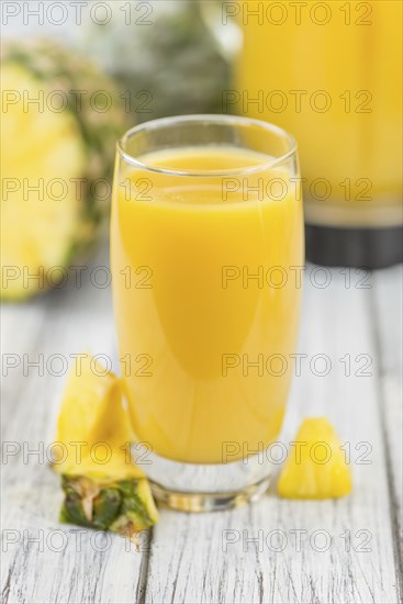 Fresh made Pineapple Juice on an old and rustic wooden table, selective focus, close-up shot