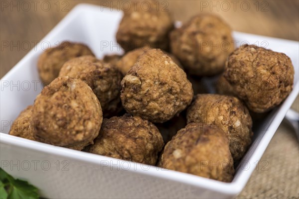 Some fresh made Meatballs on wooden background (selective focus, close-up shot)