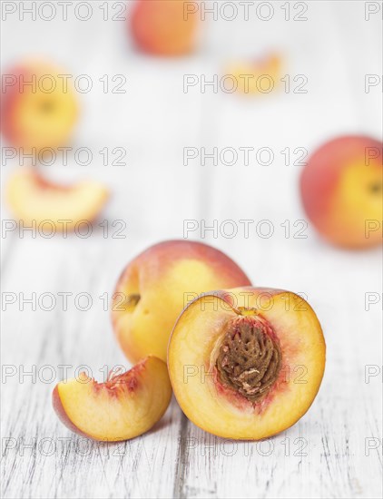 Peaches on an old wooden table as detailed close-up shot, selective focus