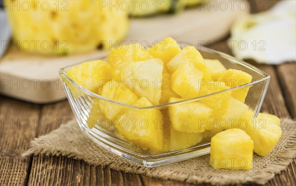 Sliced Pineapple on rustic wooden background as close-up shot
