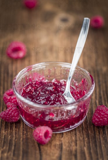 Fresh made Raspberry Jam on an old and rustic wooden table, selective focus, close-up shot