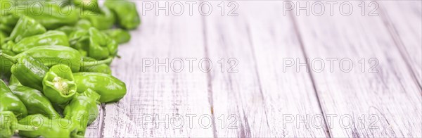 Raw Pimientos on rustic wooden background as close-up shot