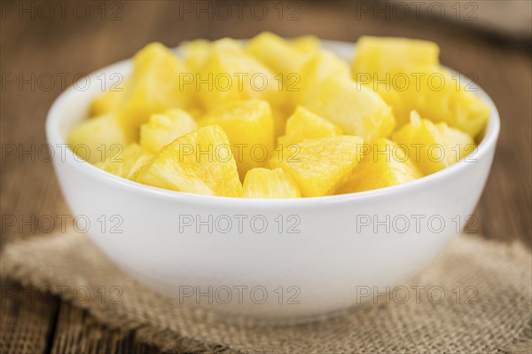 Sliced Pineapple on an old wooden table as detailed close-up shot, selective focus