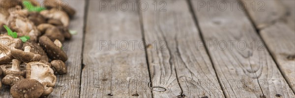 Shiitake mushrooms on an old wooden table as detailed close-up shot, selective focus