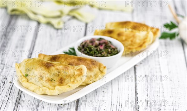 Portion of healthy Empanadas on an old wooden table (selective focus, close-up shot)