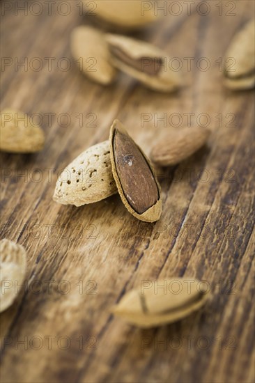 Roasted and salted Almonds (with shell) on a vintage background (close-up shot)