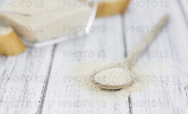 Wooden spoon with Breadcrumbs (close-up shot, selective focus) on an old wooden table