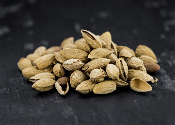 Almonds in shell (roasted and salted) on a vintage background (close-up shot)