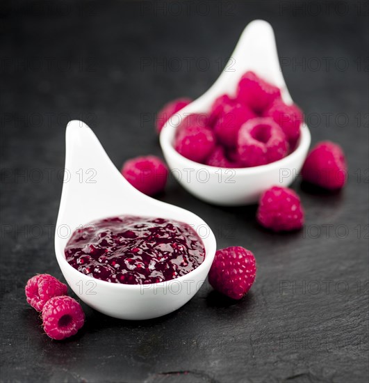 Portion of Raspberry Jam on a rustic slate slab, selective focus, close-up shot