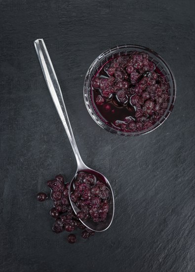 Some fresh Preserved Blueberries on a vintage slate slab, selective focus, close-up shot