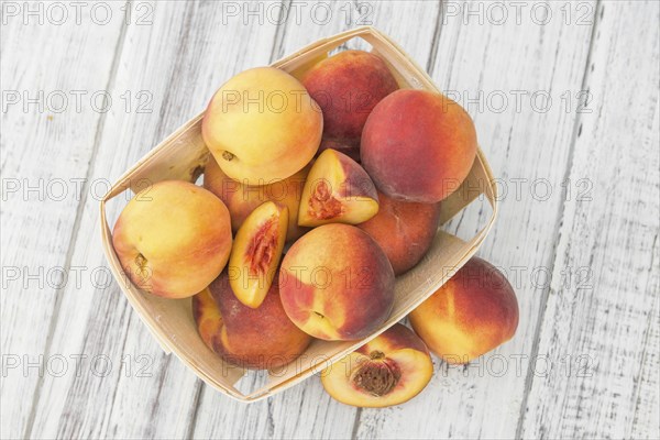 Fresh Peaches as high detailed close-up shot on a vintage wooden table, selective focus