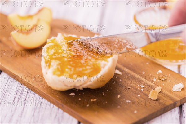 Peach Jam on an old wooden table as detailed close-up shot, selective focus