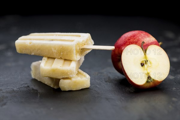 Portion of homemade Apple Popsicles (selective focus, close-up shot) on a vintage background