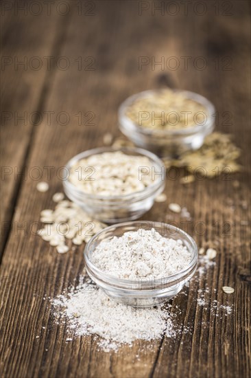 Vintage wooden table with Oat Flour (selective focus, close-up shot)